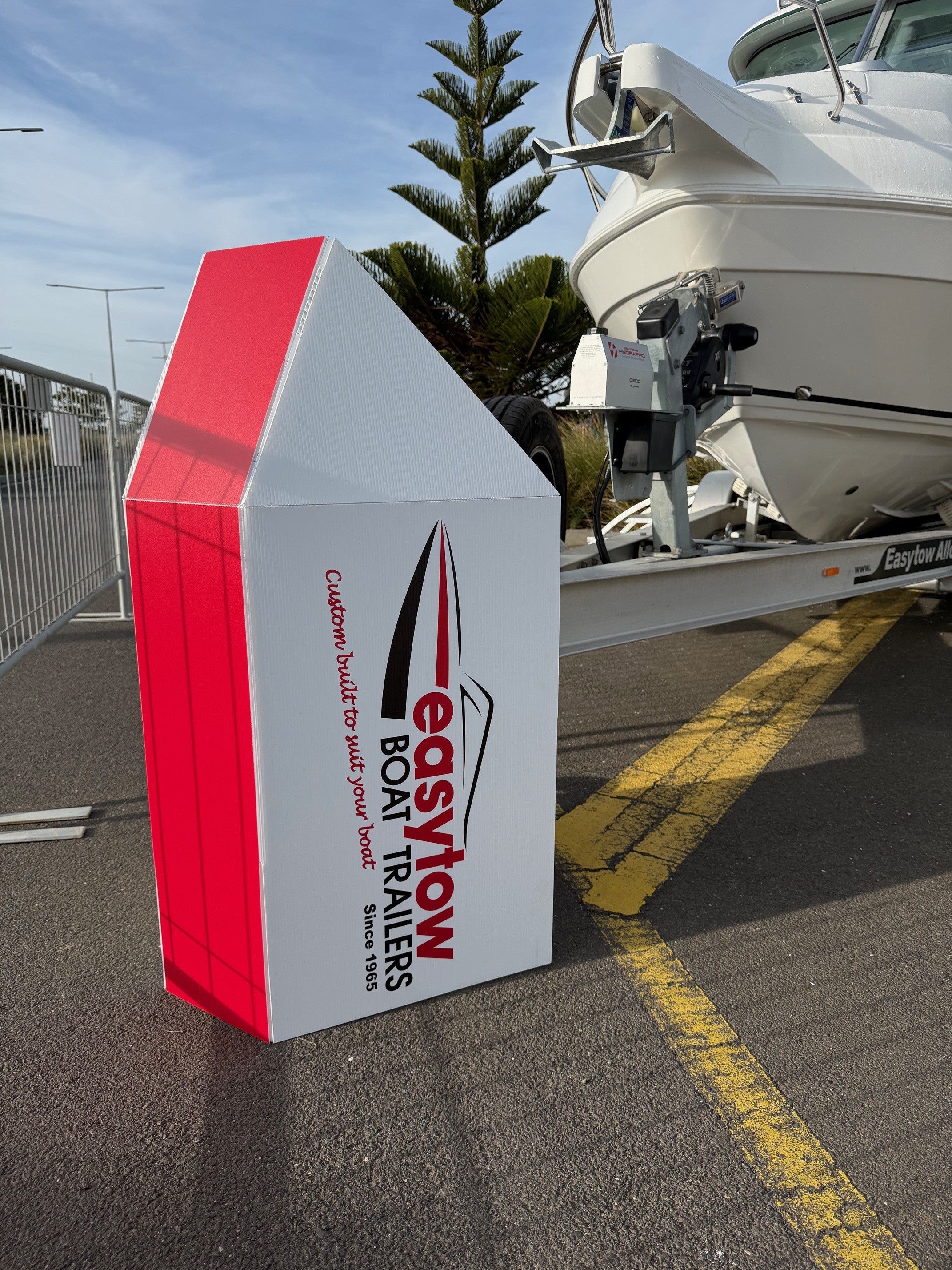Banded trailer guard made from coreflute to stop the public tripping at a boat show, branded with easytow boat trailer branding.